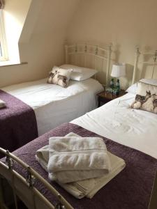 SmallburghThe Crown Inn Smallburgh的一间卧室配有两张带毛巾的床