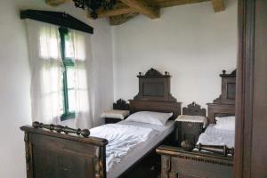 Păuleni-CiucHillside View Cottage - Csíksomlyó-panoráma vendégház的一间卧室设有两张单人床和两个窗户。