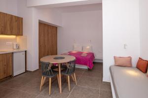 提诺斯普拉西诺奥尼罗公寓的小房间设有一张床、一张桌子和椅子