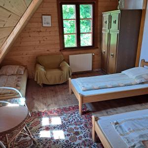 Dom Glówny的小屋内带两张床和椅子的房间