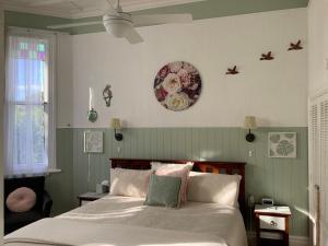 旺阿雷切尔西之家住宿加早餐酒店的卧室配有一张床,墙上挂着一个钟