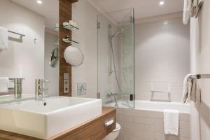 科隆城市宫殿酒店的浴室配有水槽、淋浴和浴缸。