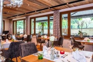 格罗萨尔Hotel Schiederhof的餐厅设有桌椅和大窗户。