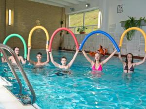 旧柳博夫尼亚Hotel SOREA ĽUBOVŇA的一群儿童在游泳池玩耍