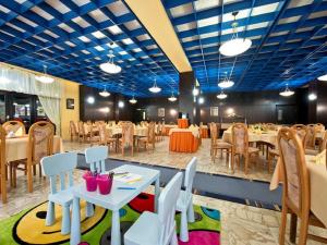 旧柳博夫尼亚Hotel SOREA ĽUBOVŇA的一间设有桌椅的用餐室和蓝色的天花板