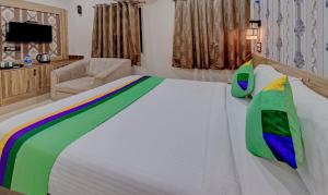 蒂鲁帕蒂Treebo Trend Seven Inn的卧室配有一张白色大床和椅子