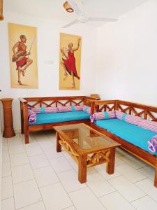 迪亚尼海滩Pendo Villas Diani Beach的客房设有两张床和一张茶几