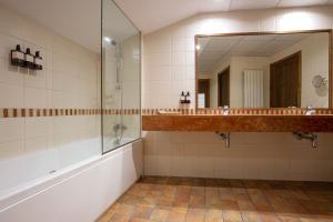 马萨纳Hotel Màgic Ski的带淋浴、盥洗盆和镜子的浴室