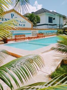 迪亚尼海滩Pendo Villas Diani Beach的大楼前带长椅的游泳池