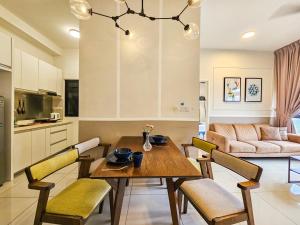 努沙再也Meridin Medini Suite by Nest Home【LEGOLAND】的厨房以及带木桌和椅子的客厅。