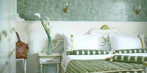 贝尔格莱德皇后阿斯托利亚设计酒店的一间卧室设有两张床和花瓶
