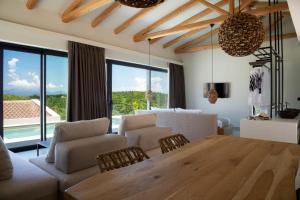Andipáta ErísouAmahle Luxury Villas 2023的客厅配有木桌和椅子,客厅