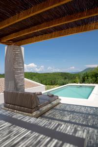 Andipáta ErísouAmahle Luxury Villas 2023的一个带躺椅的甲板和一个游泳池