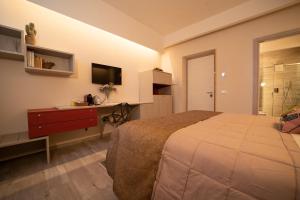 塔兰托San Nicolicchio - Luxury Guest House的一间卧室配有一张床、一张书桌和一台电视
