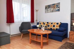 比克碧姬布克法都公寓的客厅配有蓝色的沙发和桌子