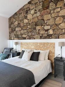 ValhelhasQuinta da Pedrulha的一间卧室设有石墙和一张大床