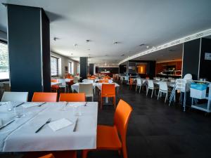 普拉德埃米塔Apartamentos La Solana的用餐室配有白色的桌子和橙色的椅子