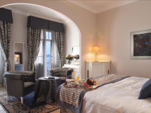 加尔多内-里维耶拉加尔多内大酒店的酒店客房带一张床、一张桌子和椅子