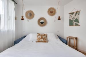 里夫杜海滩Cocon apaisant a Rivedoux Plage的一间卧室配有一张带枕头的床