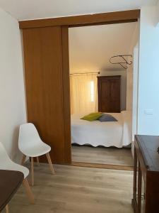 莱里奇La Casetta的一间卧室配有一张床和一张白色椅子
