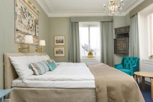 斯德哥尔摩Lady Hamilton Hotel的一间卧室配有一张大床和蓝色椅子