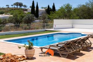 阿尔布费拉#102 Villa Private Pool and Garden的一个带2把躺椅的游泳池和一个游泳池