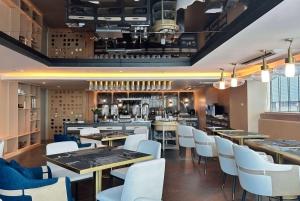 曼谷Ramada by Wyndham Bangkok Sukhumvit 11的配有木桌和白色椅子的餐厅