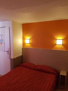 豪森HECO Colmar Nord - ex Première Classe的卧室配有一张床,墙上有两盏灯