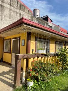 马斯巴特Maria Kulafu Studio Apartment Kinamaligan- Beside Eglin Gas FREE Wifi的前面有栅栏的黄色房子