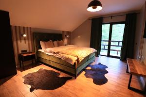 RausorWild Hunts Lodge Retezat的卧室配有一张床,地板上铺有2个地毯。