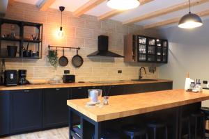 RausorWild Hunts Lodge Retezat的厨房配有黑色橱柜和木制台面