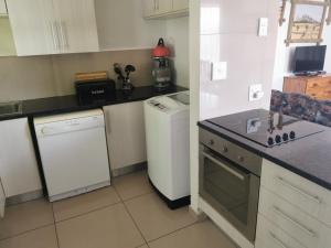 萨比Cycadales Villa的厨房配有白色冰箱和洗碗机。