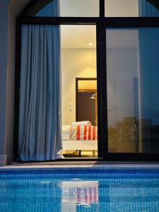 塞拉莱Hawana Lagoon Private villa with private pool的游泳池,透过窗户可欣赏到卧室的景色