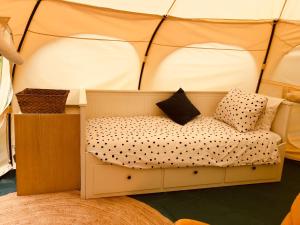 Minicamping Kleintje Zandpol的一张位于带枕头的游戏帐篷内的床铺
