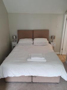 特鲁罗The Ship Inn的一张白色大床,配有白色床单和枕头