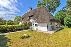 Finest Retreats - Pemberley Cottage的茅草屋顶房屋,带庭院
