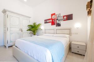 丽都玛里尼Villa Crigiada Luxury Pool的白色卧室配有大床和植物