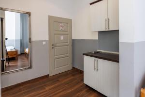 巴尼亚卢卡克比尔汽车旅馆的厨房配有白色橱柜、镜子和门