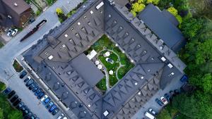 扎科帕内Aries Hotel & SPA Zakopane的享有带停泊车辆的大楼的顶部景致
