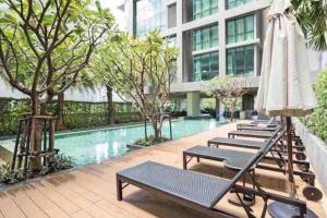 曼谷Luxurious in Prime Area Bangkok (PickupService)的酒店游泳池设有躺椅和遮阳伞