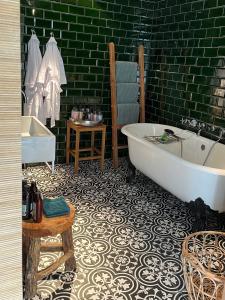 奥弗芬Suites Elswoutshoek的带浴缸和绿色墙壁的浴室