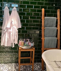 奥弗芬Suites Elswoutshoek的浴室设有绿色瓷砖墙和一张带化妆品的桌子