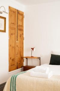 米尔芳提斯城Casa do Lado的一间卧室配有一张床和一扇木门