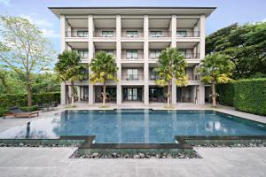乔木提恩海滩The Sala Pattaya - SHA Certified的大楼前的游泳池
