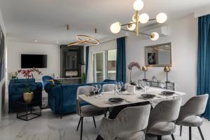 扎达尔Luxury Wellness & Spa Villa Depaja的一间带桌子和蓝色沙发的用餐室