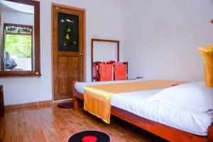 米瑞莎兰吉斯游客旅馆的一间卧室设有两张床、镜子和窗户