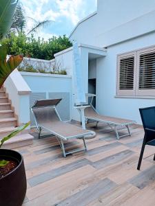 佩斯科勒海滨Pescoluse Apartments的庭院配有两把椅子和一张桌子