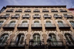 萨拉戈萨加泰罗尼亚支柱酒店的一座高高的砖砌建筑,设有窗户和阳台