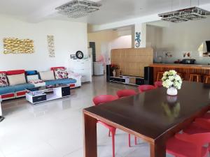 SigatokaPacific Paradise Villa的客厅配有桌子和红色椅子