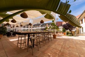 安特克拉Hotel Antequera Hills的庭院设有带椅子和遮阳伞的酒吧